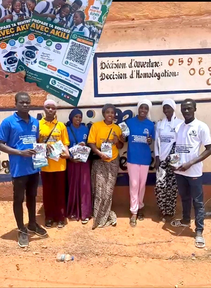 AfrJigi field team in Côte d'Ivoire holding Akili flyers in front of a school